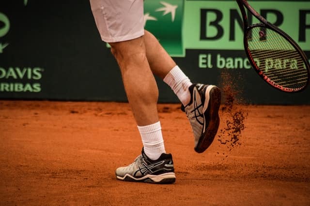 tennisman on a clay tennis court
